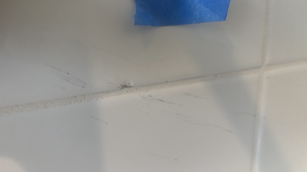 Cracked and chipped tiles requiring replacement, found during a pre-handover inspection in Mickleham